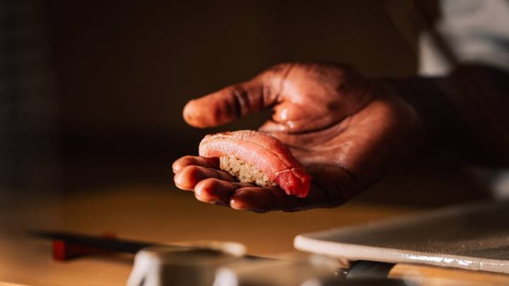 Mano del chef domingo enseñando sushi de gambas