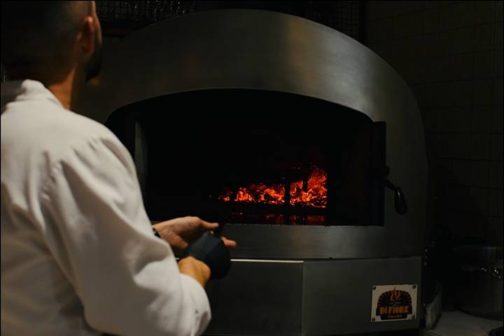 O forno a lenha que antes fazia pizzas serve agora para, entre outros, fazer o pão de massa mãe que é servido no restaurante e no hotel