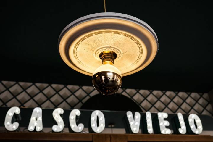 Lampara en el establecimiento 'Casco Viejo' con el nombre del local iluminado con bombillas.