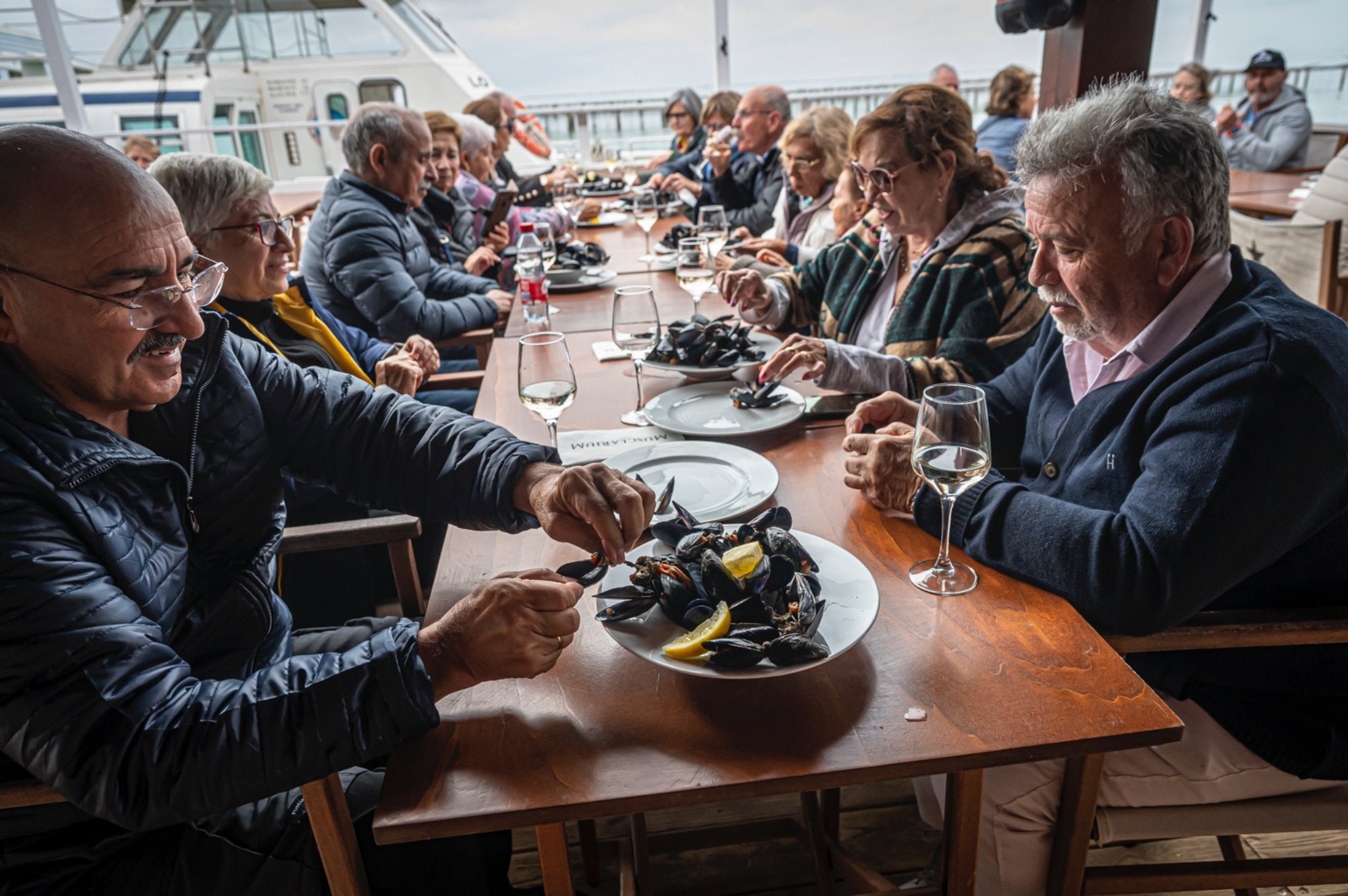 Turistas comiendo mejillones y ostras en Musclarium