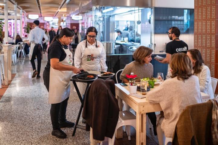 Camareras atendiendo a clientes en el mercado.