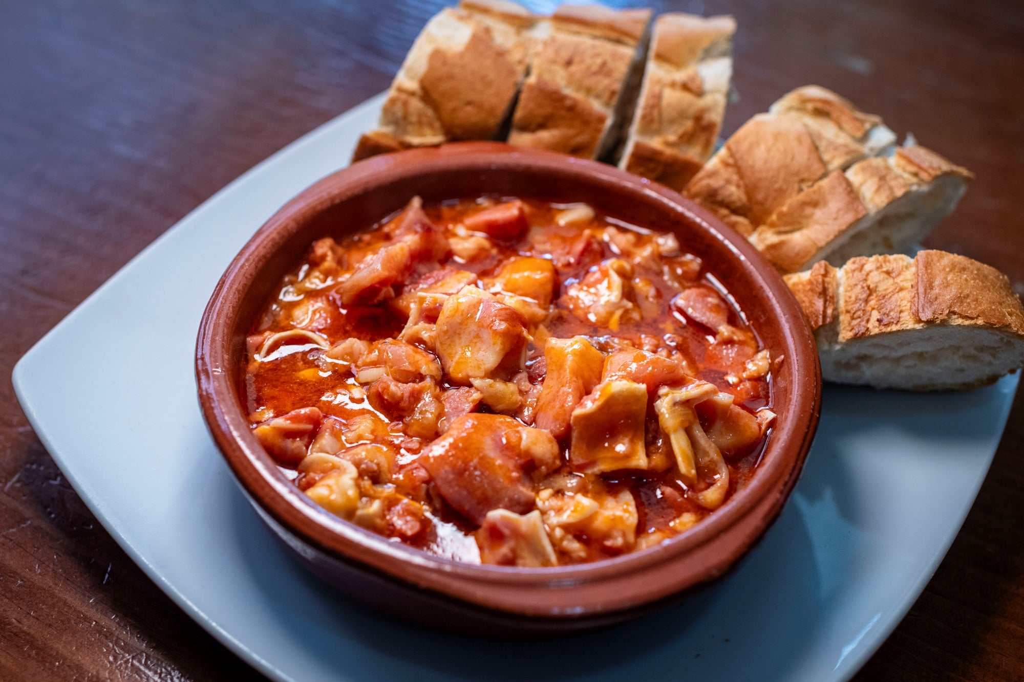 Un plato de oreja con pan de acompañamiento.