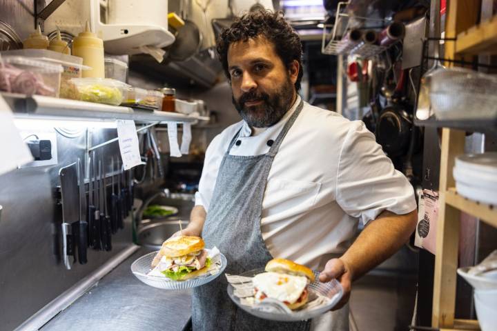 Adrián sujetando dos platos en la cocina del 'Baste'.