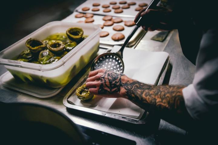 Cocinero colocando alcachofas en una bandeja.