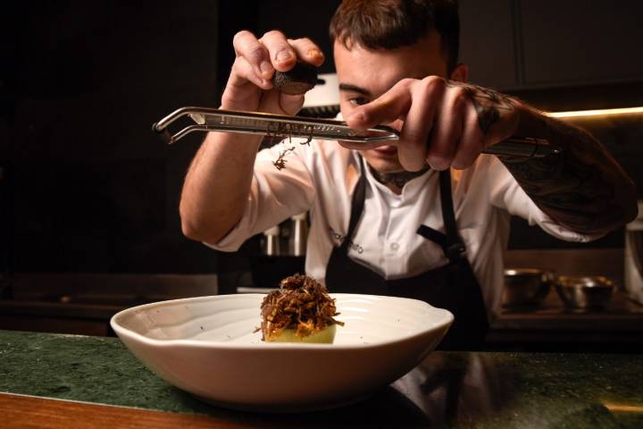 Cocinero rallando trufa sobre el plato.