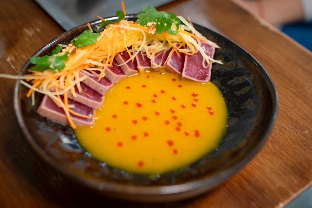 Tiradito yulibiki de atún en un aguachile de mango y curry, con ensalada thai de mango verde.