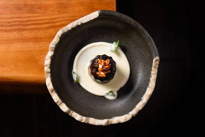 Canelé con crema de almendra amarga.