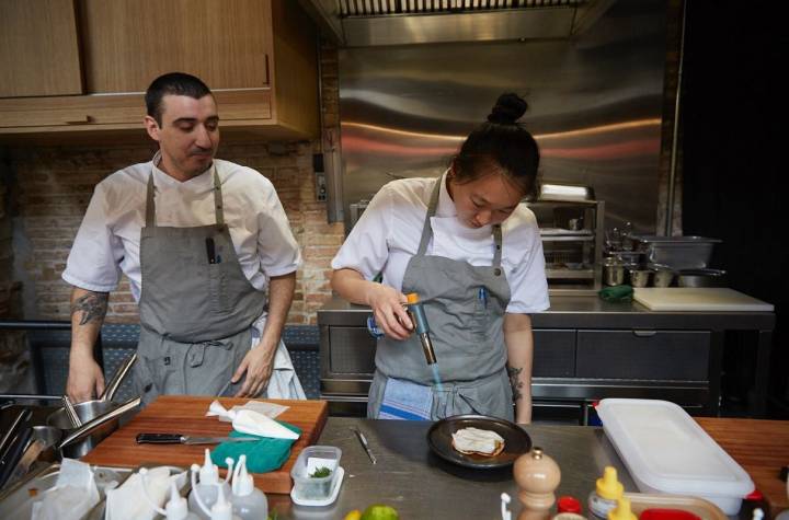 Los chefs Arnau Muñío y Shu Zhang en la cocina de la barra del restaurante Direkte Boquería, en Barcelona.