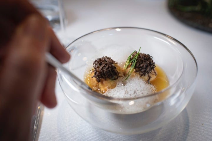 Caldo con pelotas, col asada y trufa negra.