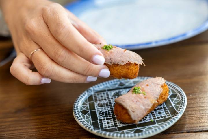 Croquetas de bechamel de kimchi sobre un pastrami hecho en casa.