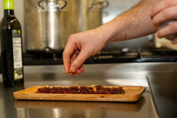 Preparación de semimojama de atún rojo con picada de tomate seco y almendras.