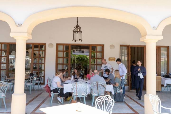 Terraza exterior y un grupo de comensales sentados a la mesa en el restaurante Cataria, en Chiclana, Cádiz.