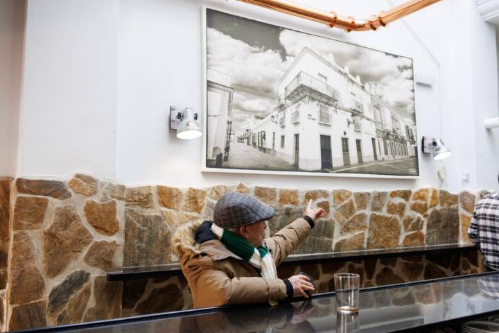 Un hombre señala una antigua foto del local.