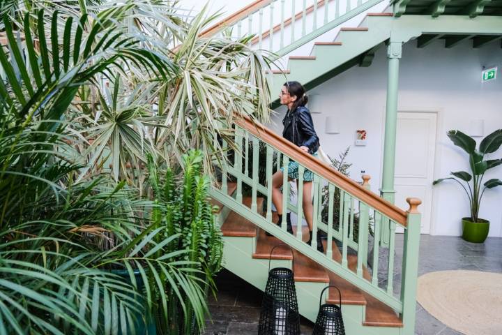 Una mujer sube las escaleras del patio interior del hotel.
