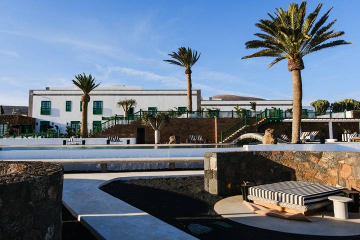 Fachada parcial del hotel, con vistas de la piscina y una de las camas balinesas.