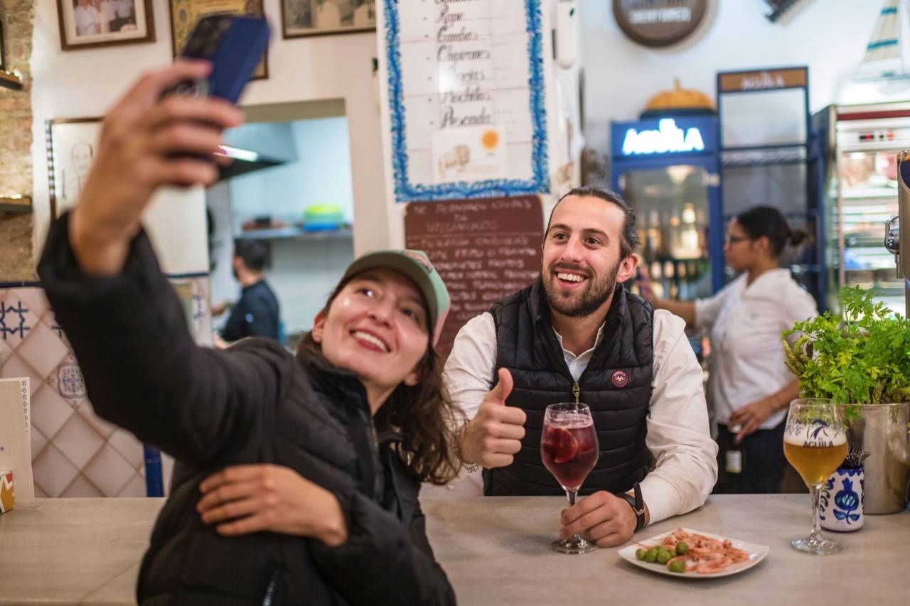 Raúl Romero, del Bar Provincias de Granada, junto a una clienta.