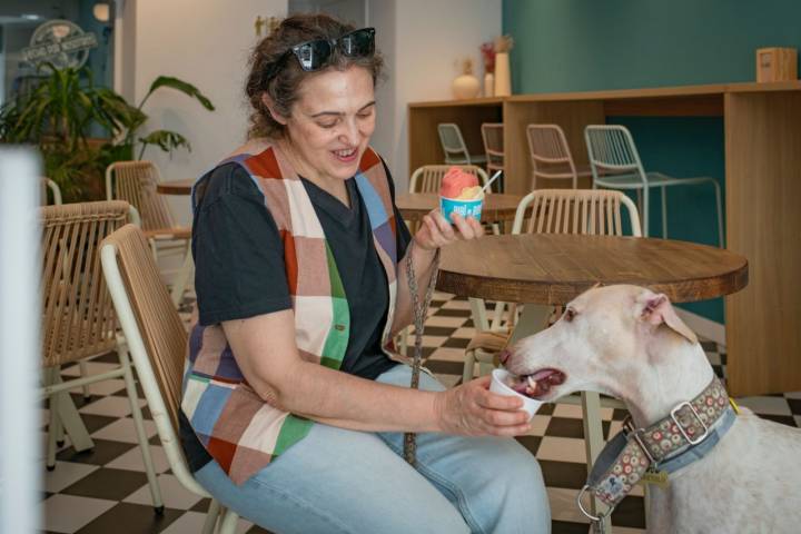 Una clienta compartiendo un helado con su mascota