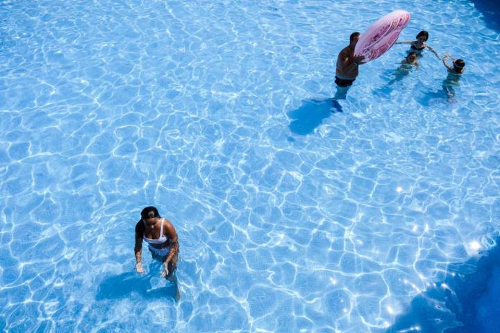 Una adolescente se baña entre los reflejos del sol en las aguas claras de una de las piscinas más grandes.