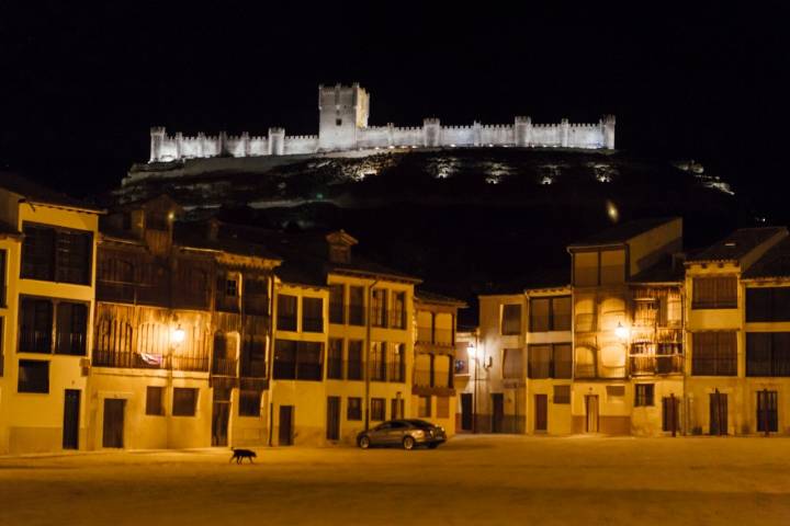 El castillo iluminado sobre el pueblo y la plaza del Coso a sus pies.