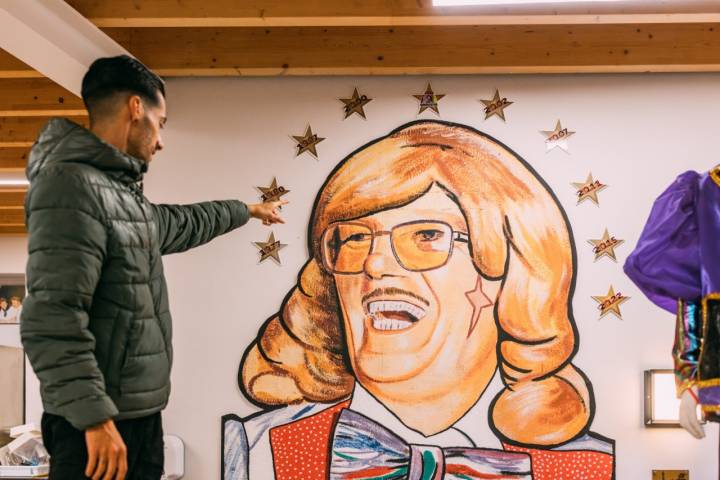 Tony con el mural del retrato de su abuelo, fundador de la murga