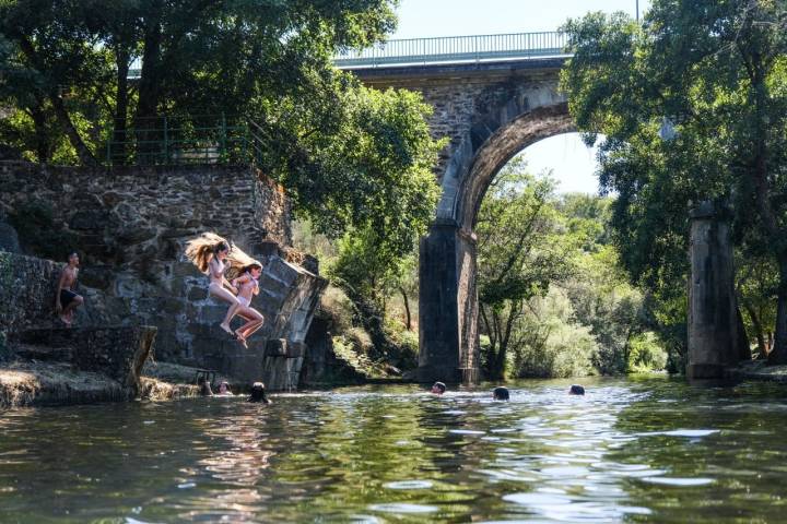 Dos niñas saltan en la piscina natural de Perales del Puerto en Sierra de Gata.