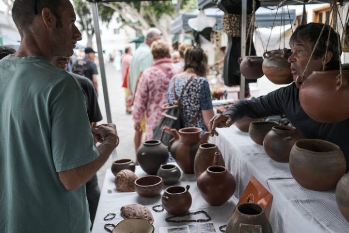 Aquilino habla con un cliente en su puesto de cerámica tradicional canaria.