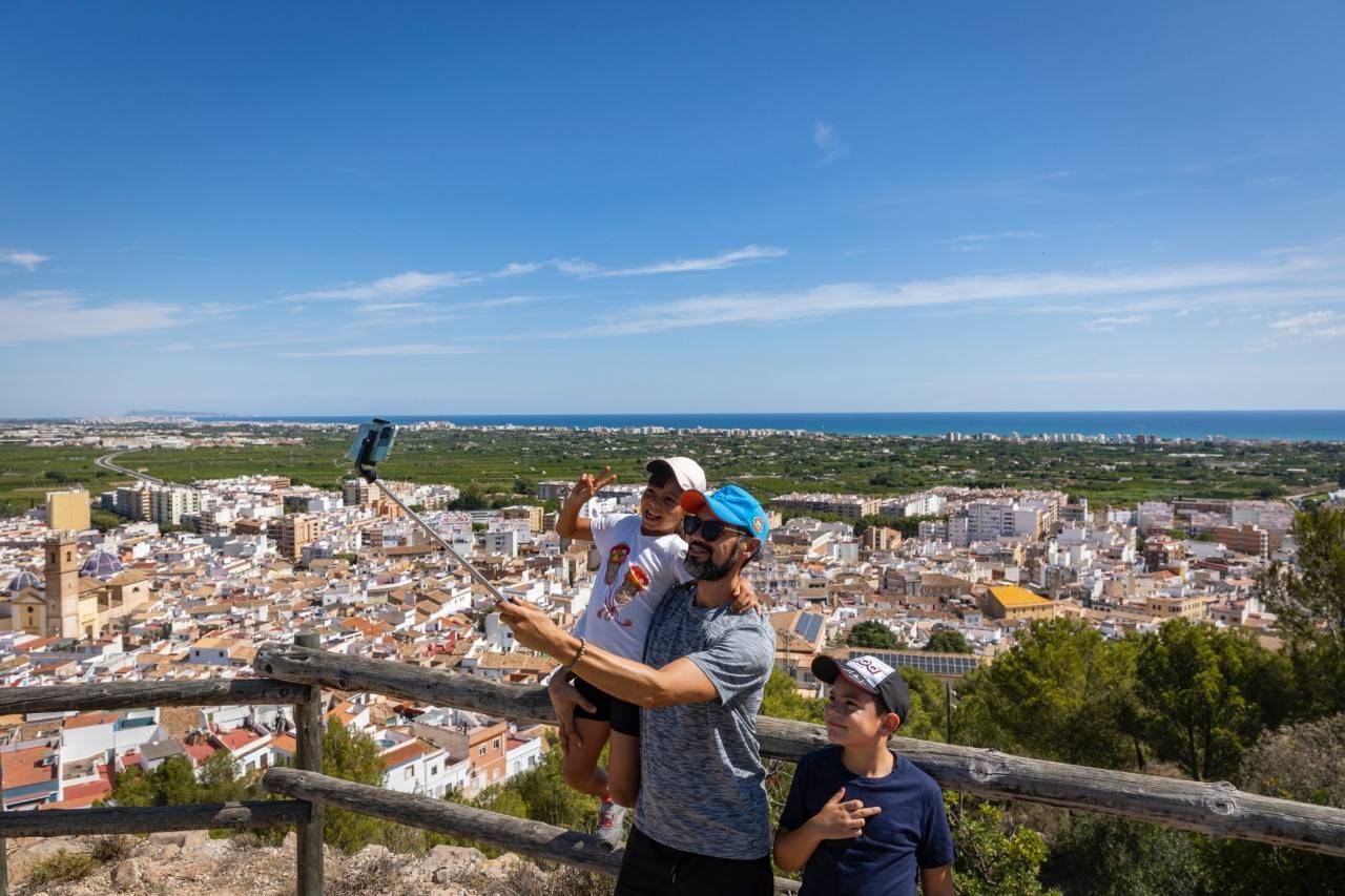 Una familia se hace una foto con las vistas de Oliva