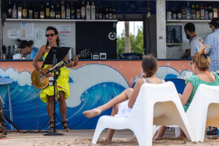 Una cantante interpreta una canción en el chiringuito de la playa de Aigua Morta.