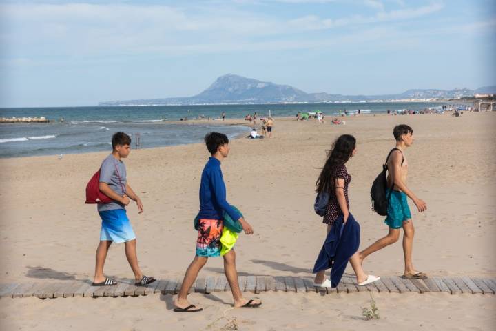 Unas personas caminan por la playa.