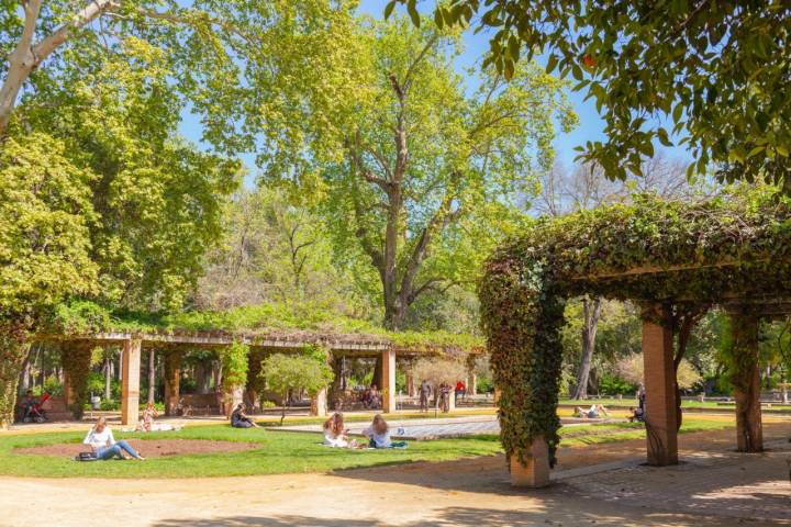 Seville, Spain - 7th April 2022. People enjoying a sunny April afternoon in the Maria Luisa Park in central Seville, Spain. Some are out in the sun, others are taking advantage of the shade of some pergolas.