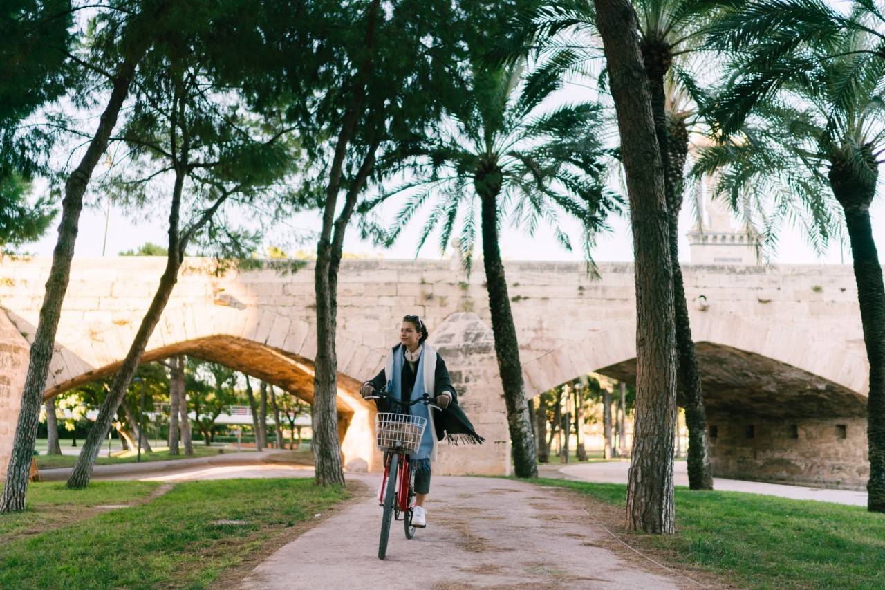 Young woman riding a bicycle in Valencia and exploring the city