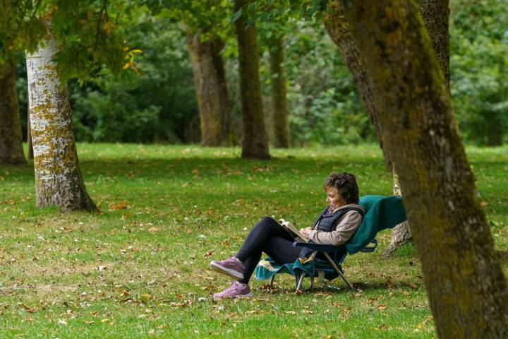 Una mujer lee sentada en el Parque Provincial de Landa