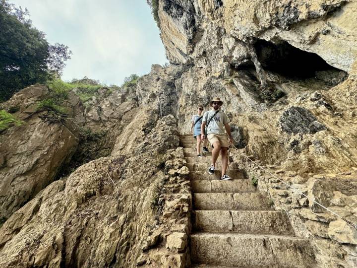 Dos personas descienden la escalera que conduce al faro del Caballo