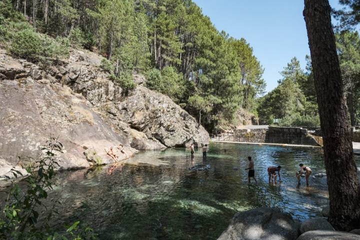 Varios bañistas dentro del Charco Verde de Guisando.