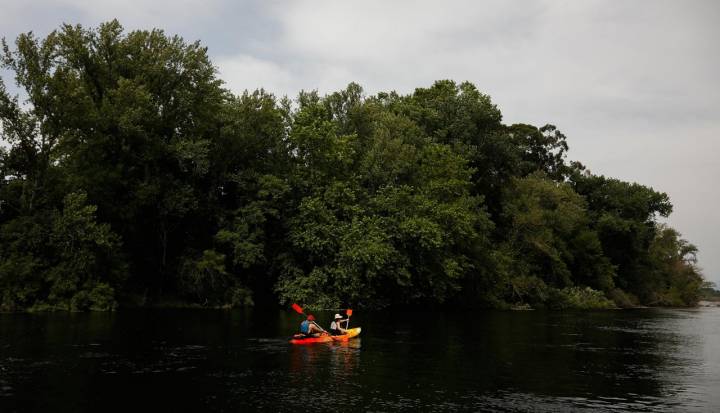 Dos personas en kayaks en el río.